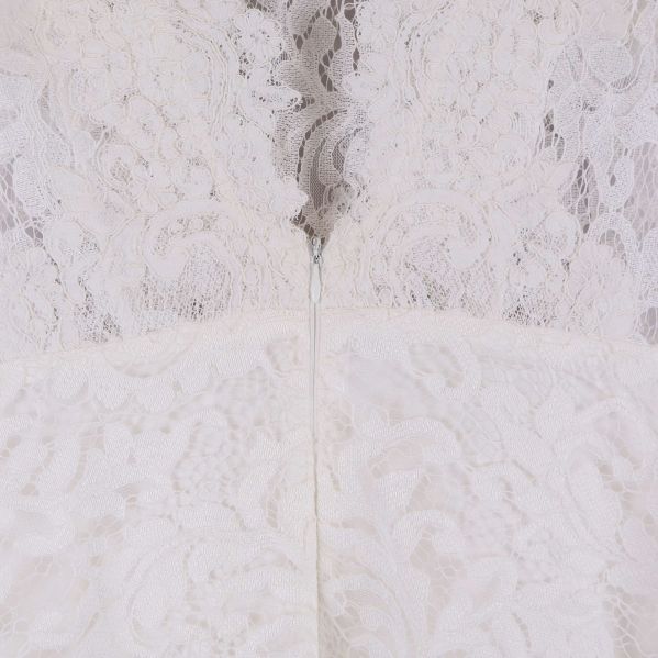 Närbild på dragkedjan bak på vit spetsklänning