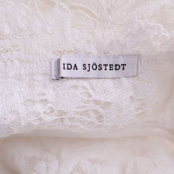 Ida Sjöstedt varumärkesetikett i vit spetsklänning