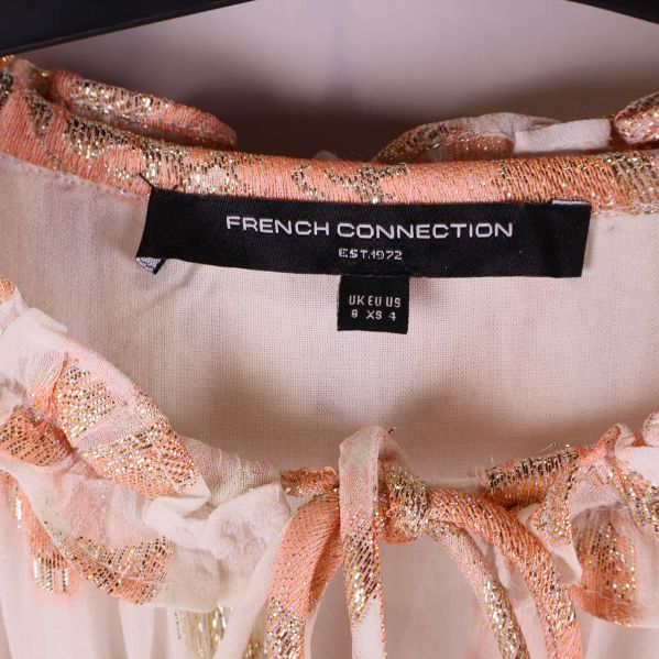 Etikett med texten French Connection samt storlek