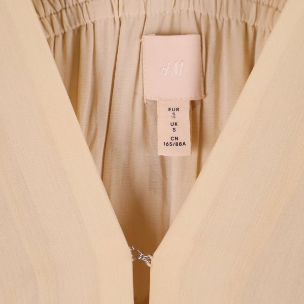 Närbild på etikett med H&M-logotyp i klänningen