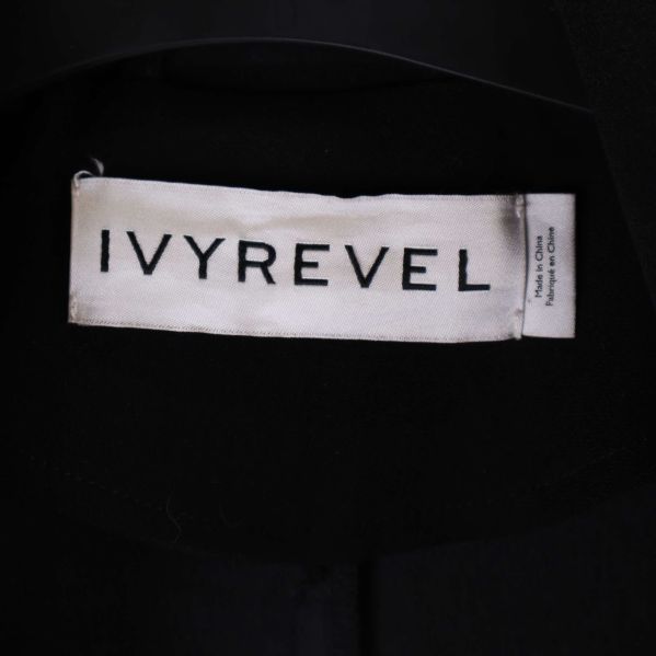 Närbild på IVYREVEL-loggan på kappans inneretikett