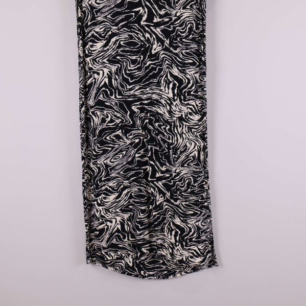 Närbild på nederdelen av svartvit klänning med svängd fåll