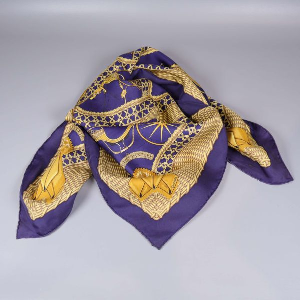 Scarf med gult grafiskt mönster draperad på underlag