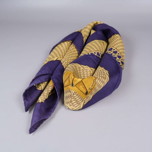 Sidenlik scarf vikt och rullad i blått och gult