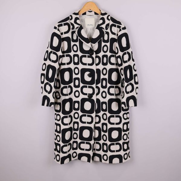 Kappa med svartvitt grafiskt mönster framifrån på galge