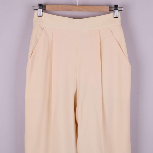 Överkant och fickor av beige byxa med veck