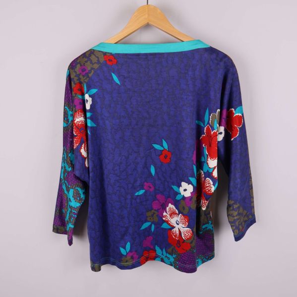 Baksida av tröja med blått blommönster och färgglada detaljer