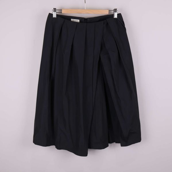 Svart midikjol med veck fotograferad framifrån