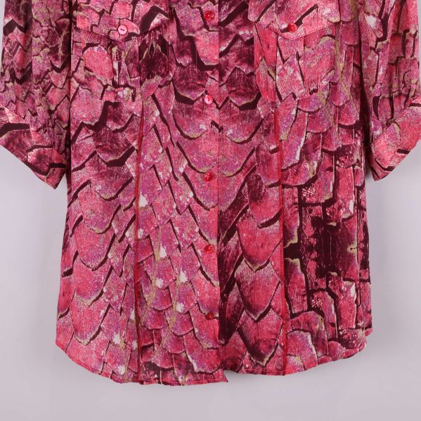 Närbild på blusens nedre del och mönster i rosa toner