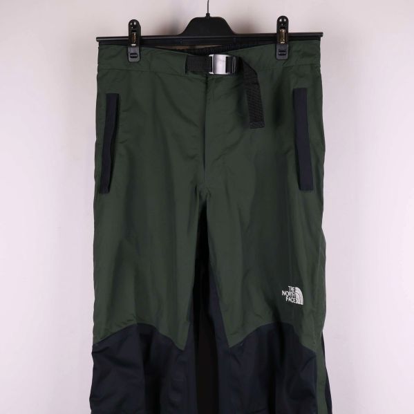 Övre delen av gröna byxor med dragkedjefickor och bälte