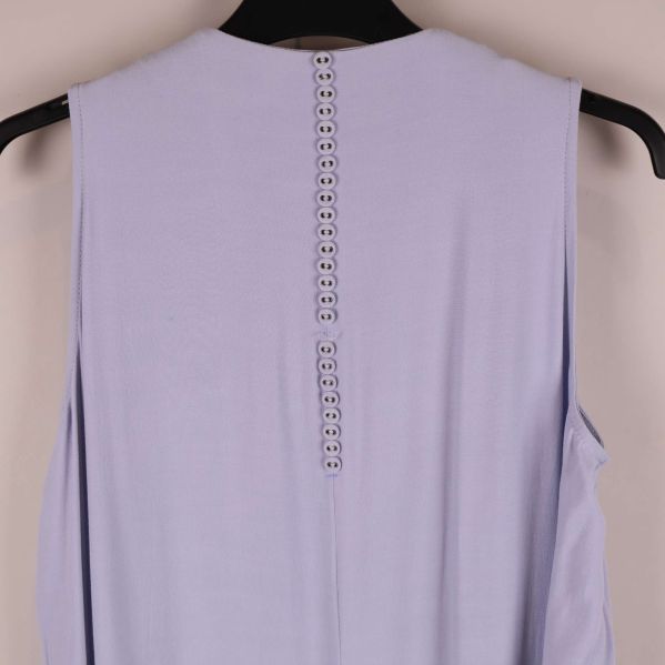 Närbild av knapprad längs rygg på klänning