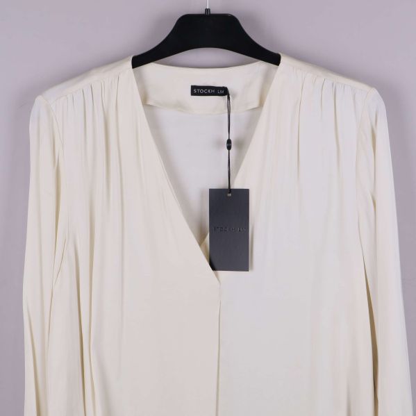 Närbild på blusens v-ringning och axelparti