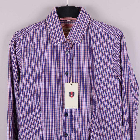 Närbild på skjortans framsida med knäppning och etikett