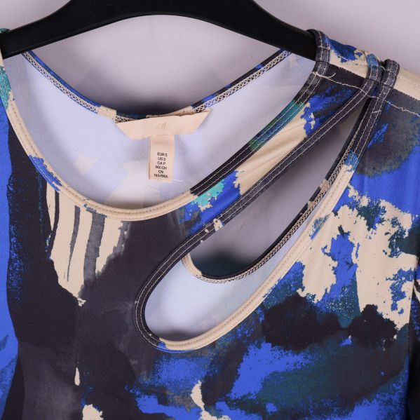 Närbild på asymmetrisk halsringning med cut-out