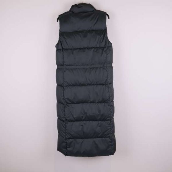 Baksidan av lång svart vadderad väst syns mot ljus bakgrund
