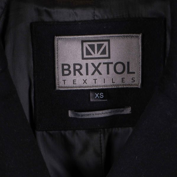 Närbild på Brixtol Textiles-logotyp och storlek XS i kappan