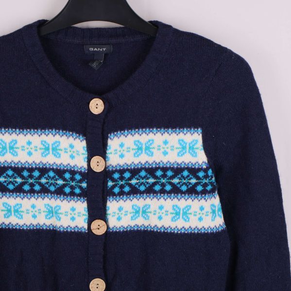 Närbild på mönstrad panel och knappar på koftan