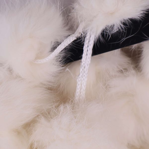 Närbild på två vita dragsnören bland tofsarna