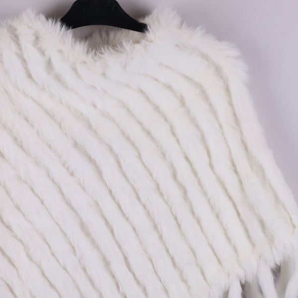 Närbild på ponchons mjuka pälstextur och diagonala ränder