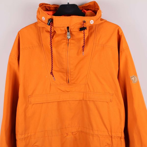 Närbild på orange anorakens huva med snören och dragkedja