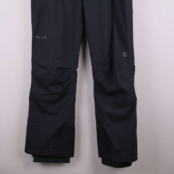 Nedre delen av svarta skidbyxor med förstärkta benslut