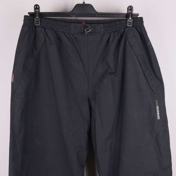 Närbild av fickor och midja på svarta byxor