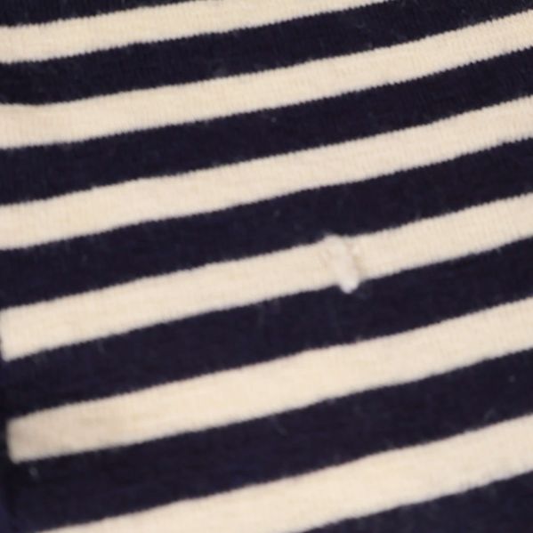 Närbild på lagad maska på randig stickad halsduk