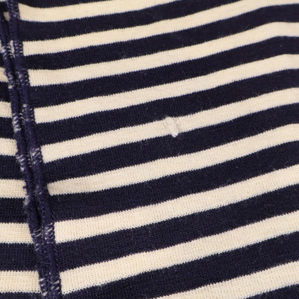 Detaljerat foto av lagning på mörkblå- och vitrandig halsduk