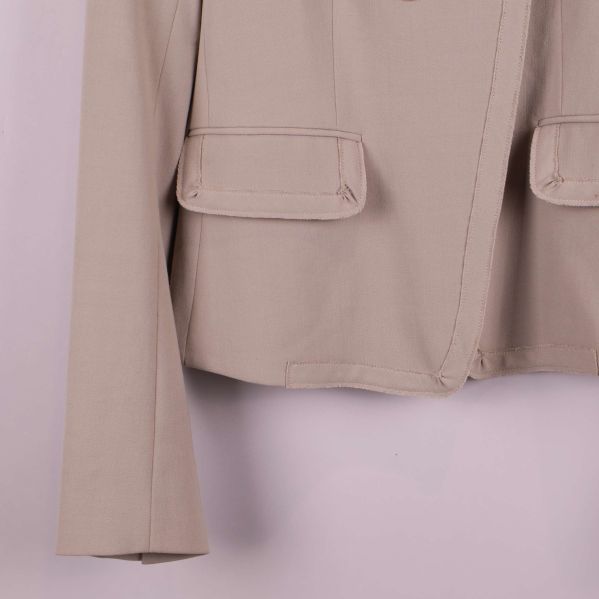 Närbild på ficka och ärm i beige kavaj