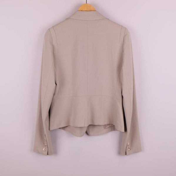 Baksidan av beige kavaj med raka linjer och slits