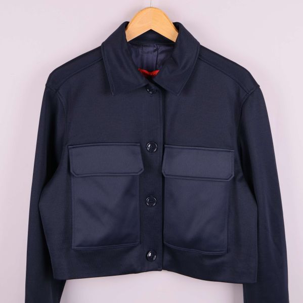 Närbild fram på mörk jacka med knappar och fickor