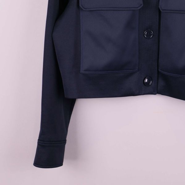 Närbild på nedre delen av jackans ärm och ficka