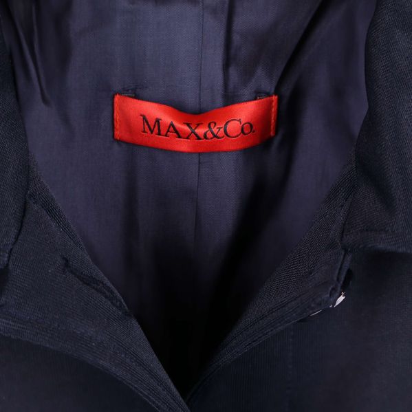 Närbild på röd MAX&Co.-etikett i jackan