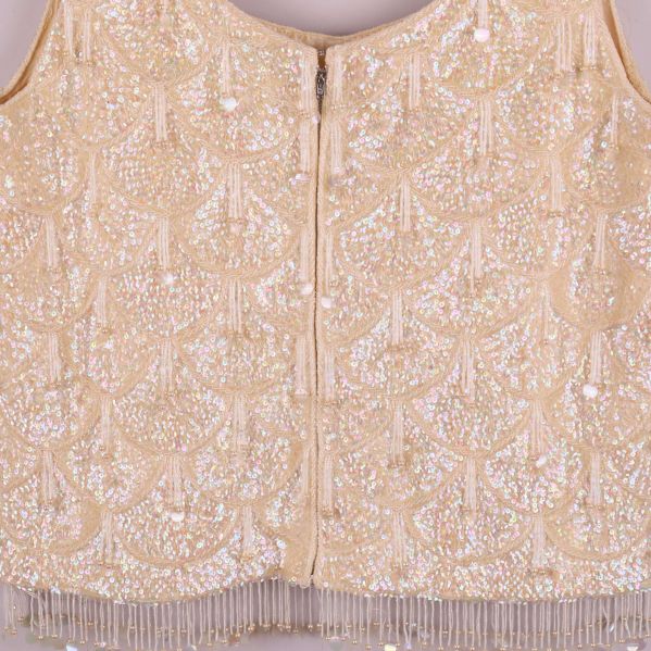 Närbild på pärlbroderi och dragkedja bak