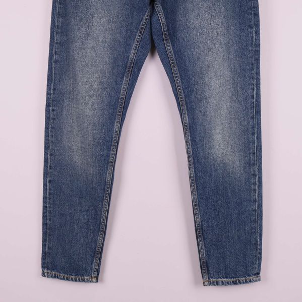 Ben och benslut på blå jeans i närbild