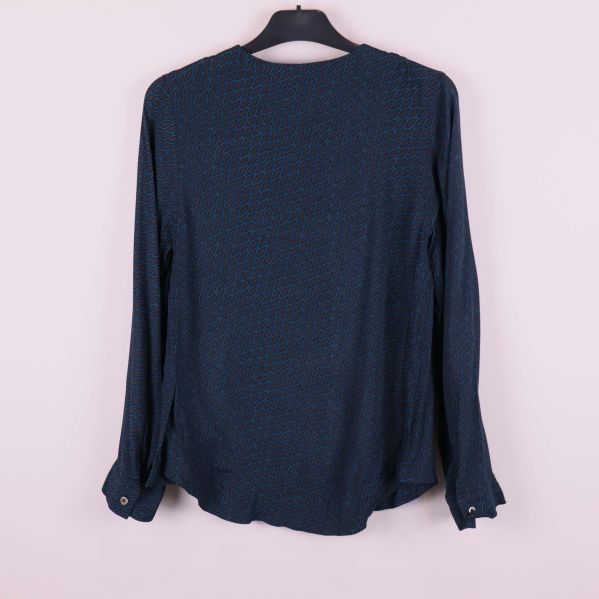 Baksidan av långärmad blåmönstrad topp på galge