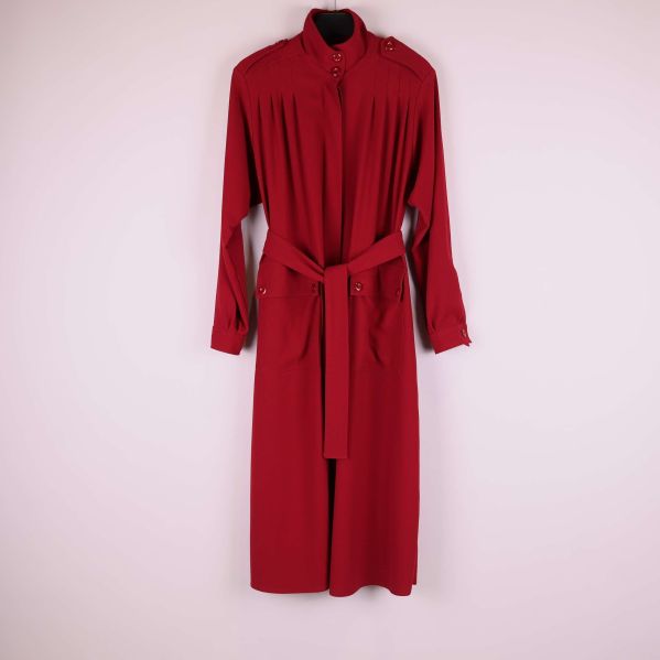 Lång röd kappa på galge mot ljus bakgrund