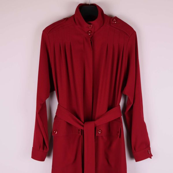 Överkropp och axelparti på röd kappa med knappar