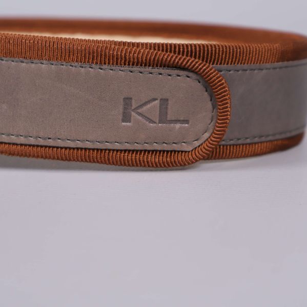 Närbild på KL-logotyp på bältesremmen