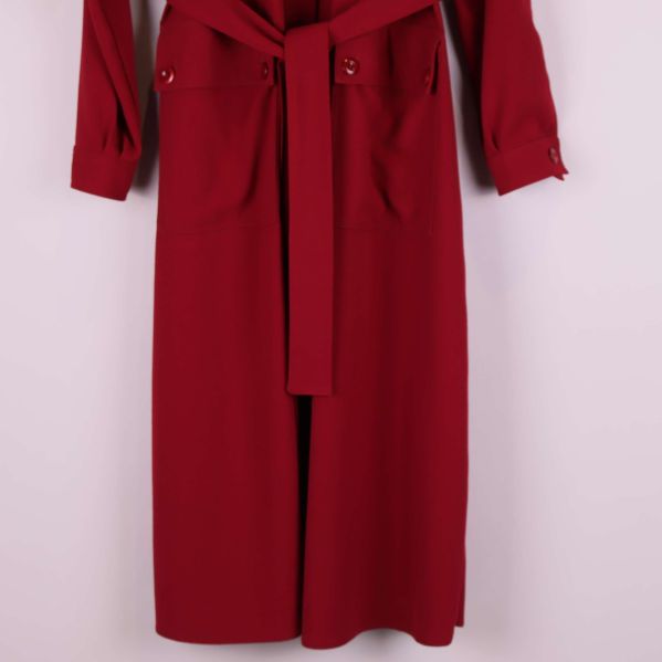 Närbild på kappa med bälte och fickor framtill