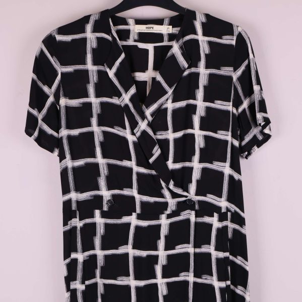 Närbild på omlottkrage och knappar på rutmönstrad klänning