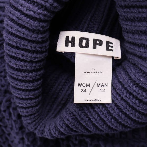 Närbild på HOPE-logotyp och storleksetikett inuti kragen