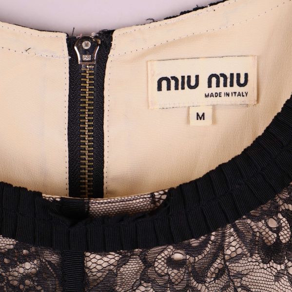 Närbild på etikett med Miu Miu logotyp och storlek M