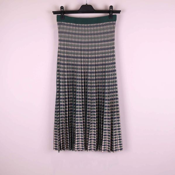 Plisserad kjol med grafiskt mönster hänger på galge