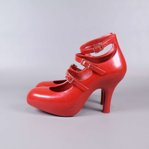 Höger röd pumps sedd från sidan och tre remmar