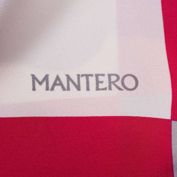 Närbild av Mantero-logotyp på färgglad scarf