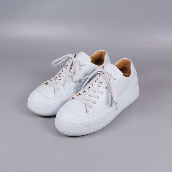 Vita sneakers med platåsula och snörning fotade snett framifrån