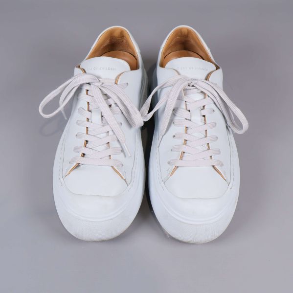 Vita sneakers fotade ovanifrån med snörning synlig