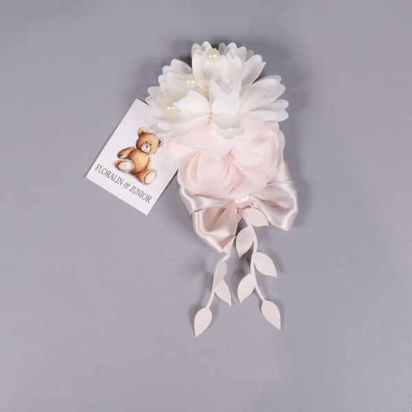 Närbild på blomdekor med vita och rosa blommor samt satinband