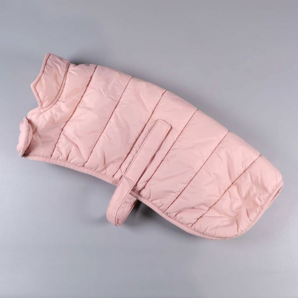 Ljusrosa vadderad hundjacka liggande platt mot ljus bakgrund